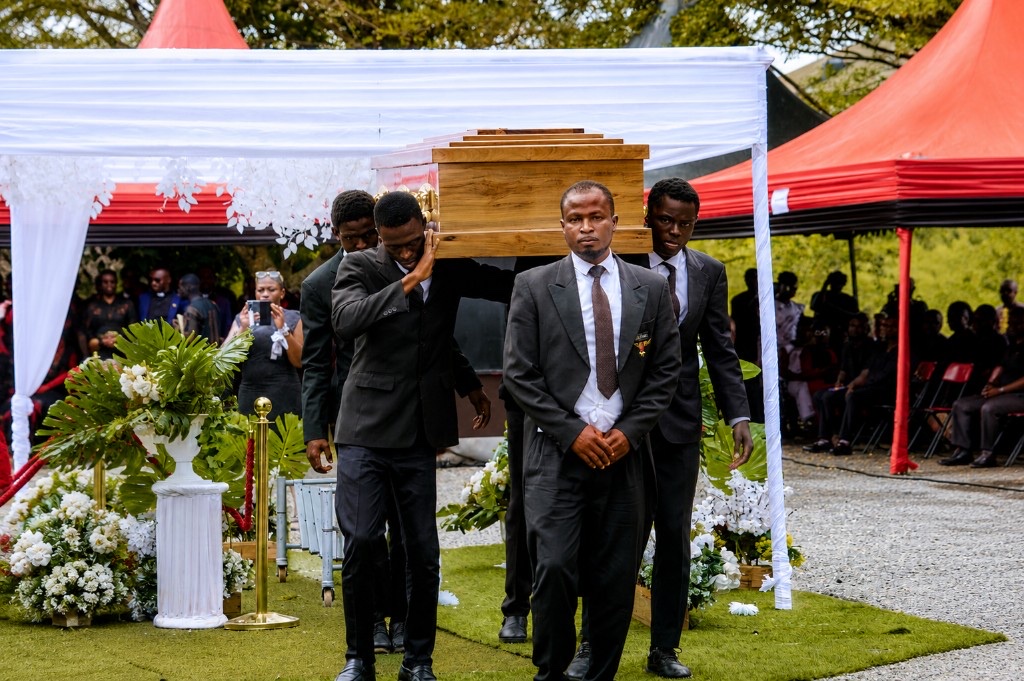 FamilyCare pall bearers carrying a casket at a Ghanaian funeral